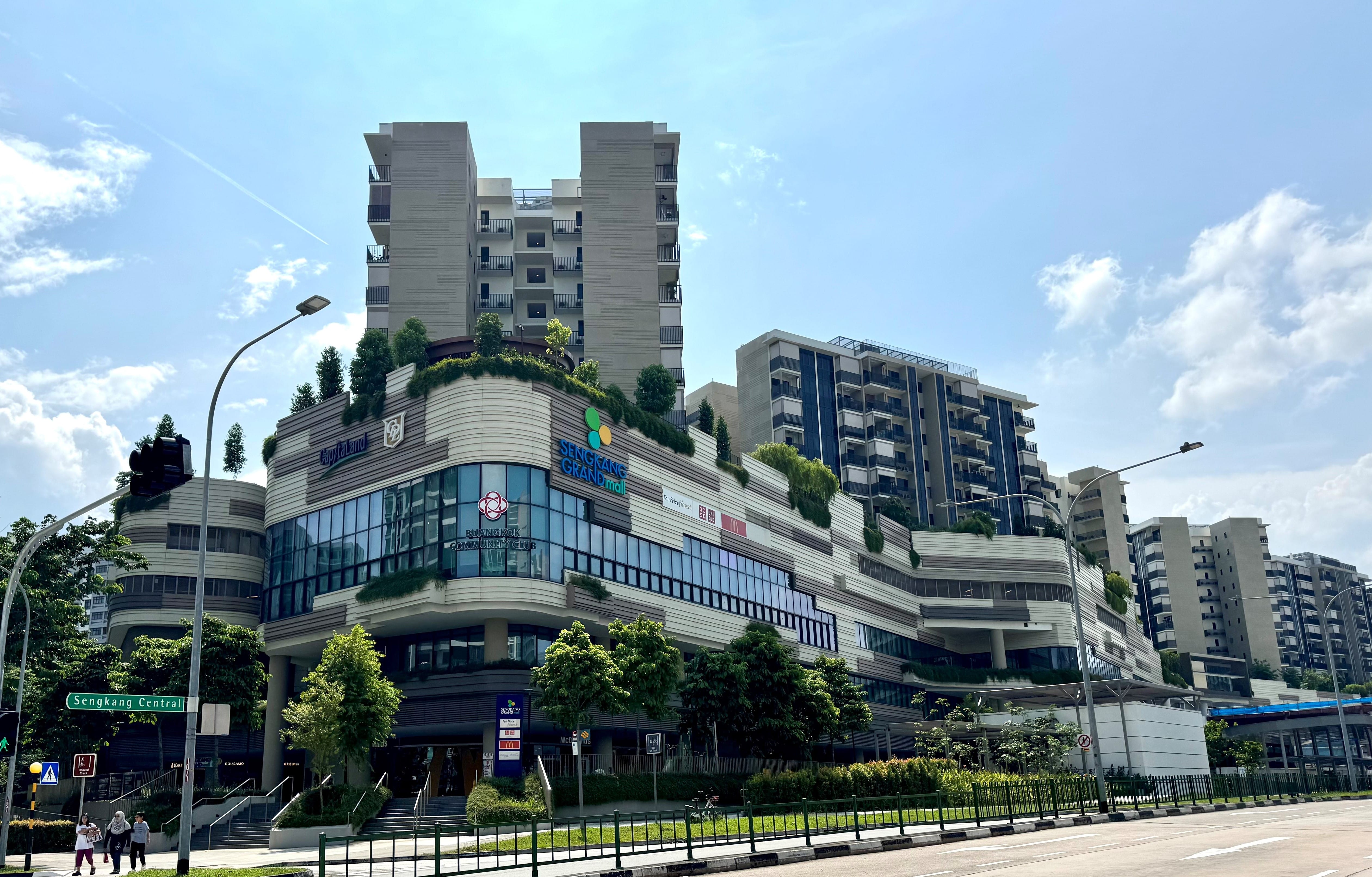 Sengkang Grand Mall, Singapore, a multi-story building with shops and residential levels, under a blue sky.